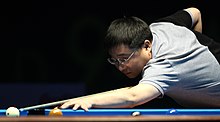 Li Hewen playing a shot