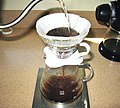 Image 44In a pour-over, the water passes through the coffee grounds, gaining soluble compounds to form coffee. Insoluble compounds remain within the coffee filter. (from Coffee preparation)