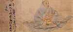 Three-quarter view of a seated man in a wide robe holding a stick like object. On the left there are three lines of text in Chinese script.