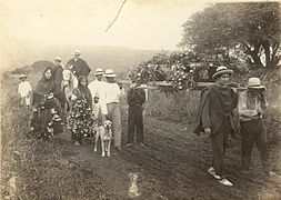 Photo en noir et blanc montrant une procession funéraire avec une dizaine de personnes et quelques animaux autour d'un cercueil porté par quatre hommes