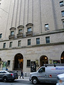 The 56th Street facade of City Center. The base is made of limestone and contains several arches. The upper stories have few windows and are made of brick.