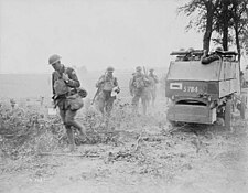 Canadian troops supported by an armoured car go into action at the Battle of Amiens