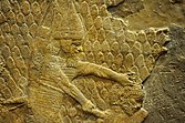 Relief depicting an Assyrian soldier about to behead a man