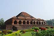 Rasmancha, Bishnupur. Built by King Bir Hambir, the temple has an unusual elongated pyramidical tower, surrounded by hut-shaped turrets, which were very typical of Bengali roof structures of the time.