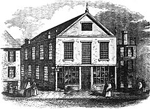 A black-and-white engraving depicting a street scene with a 2.5-story church with mullioned windows at center.
