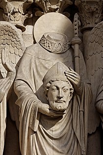 O mártir São Dinis, segurando a cabeça, sobre o Portal da Virgem (Notre-Dame de Paris)