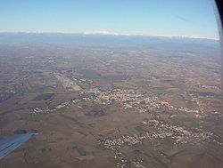 Aerial view of Cervignano and Terzo di Aquileia; the Alps in the background.