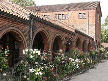 A brick cloister, built in a modified Lombard-Romanesque style