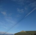 Shadow cast by vapor trail of passing aircraft