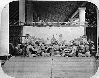 Wayang kulit (shadow puppet show) accompanied by a gamelan ensemble in Java, c. 1870.