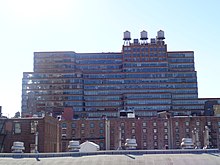 View of several buildings between 26th and 29th Streets in Chelsea, Manhattan, as viewed from the High Line. The Starrett-Lehigh Building, in the background, has a brick facade with large horizontal glass windows.