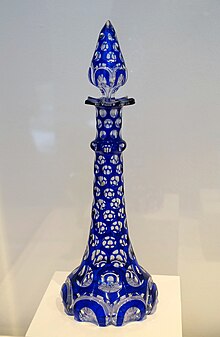 blue perfume bottle that looks like a candel with clear glass among the blue