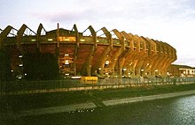 Exterior view of a stadium from across a river