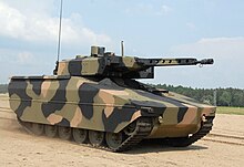Colour photo of a tracked military vehicle with a large gun turret