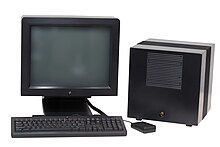 A black NeXTstation computer and a black NeXTcube workstation; the latter is housed in a cube-shaped magnesium enclosure