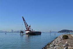 A dredge in the port with San Francisco in the background