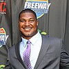 Headshot of Calais Campbell wearing a suit and smiling