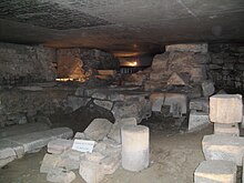 Photo de vestiges archéologiques, essentiellement des blocs de pierre, dans une crypte