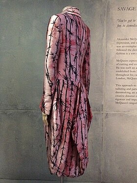 Rear view of long coat with tails, pink with a print of thorns in black