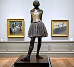 Štirinajstletna plesalka, ulita posthumno leta 1922 iz različnih modelov c. 1879–1880 bron, delno oblečena, v bombažno krilo in satenastim trakom v laseh, na leseni podlagi Metropolitan Museum of Art New York City