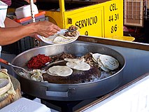 Tacos with beef suadero being prepared at a taco stand in Mexico