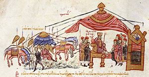 Medieval miniature showing a king with his court seated under a large tent, with horses and weapons indicating an army camp to the left