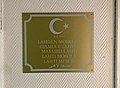 Aulassa sijaitseva kyltti, jossa lukee kaikilla rukoilijoiden enemmistökielillä "Lahden moskeija".