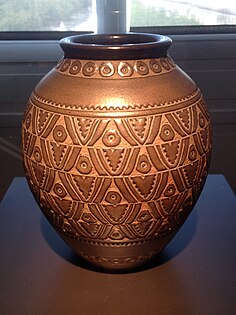 Um vaso de cerâmica inspirado em motivos da tradicional escultura esculpida em madeira africana, de Emile Lenoble (1937), Museu de Artes Decorativas, Paris.