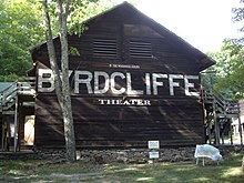 Wooden building with a stone base, and in big letters Byrdcliffe is painter across the entire side, with Theater in smaller letters below