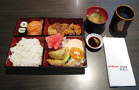 Isang bento na naglalaman ng sashimi na salmon, teriyaki na manok at gyoza, na inihain sa isang restawrang Hapones sa Jakarta.