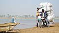 Moto transportant des marchandises sur la rive du fleuve Logone
