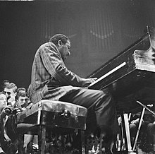 Black and white photograph of a man playing piano