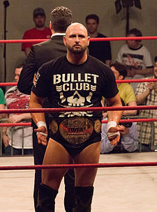 Karl Anderson, four-time IWGP Tag Team Champion, with one of the title belts in May 2014