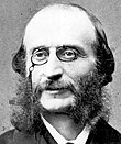 Balding, middle-aged man, with side-whiskers and pince-nez