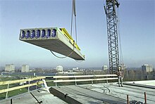 Crane manoeuvres concrete plank