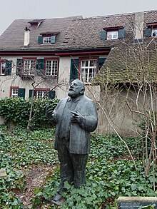 Rudolf Riggebach (1810–1863) Dänggmolpflääger, Skulptur Ditel: Dinge Dinge, vom Peter Moilliet (1921–2016) Bildhauer, uf em Lienerdskirchblatz, Standort: 47° 33′ 19,84″ N, 7° 35′ 16,67″ E