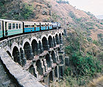 A train crossing a bridge with several arches