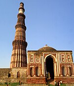 A tall minaret and a mausoleum, both in red and white stone