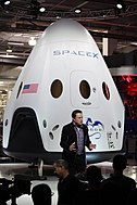 בעשור השני של המאה ה-21 חלה תנופה בקידום חקר החלל מצד גופים פרטיים. בתמונה - החללית דרגון 2, שפותחה על ידי החברה הפרטית SpaceX, לצד מייסד החברה אילון מאסק