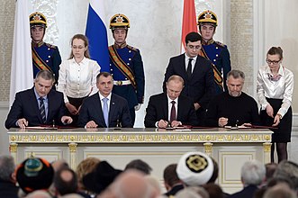 Den russiske præsident Vladimir Putin underskriver tiltrædelsestraktaten (annektering) med Krim-ledere i Moskva, d. 18. marts 2014.