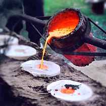 Liquid bronze at 1200 °C is poured into the dried and empty casting mould