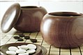 Image 18An example of single-convex stones and Go Seigen bowls. These particular stones are made of Yunzi material, and the bowls of jujube wood. (from Go (game))