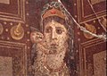 لوحة جدارية رومانية من منتصف القرن الأول قبل الميلاد في بومبي، إيطاليا، تُظهر فينوس حاملة إبنها كيوبيد وهو على الأرجح تصوير لكليوباترا السابعة من مصر البطلمية مثل تمثال فينوس جينيتريكس، مع ابنها قيصرون، وهو مماثل في المظهر إلى ما هو الآن تمثال كليوباترا المفقود الذي بناه يوليوس قيصر في معبد فينوس جينيتيكس (داخل منتدى قيصر). قام مالك بيت ماركوس فابيوس روفوس في بومبي بإغلاق الغرفة مع هذه اللوحة، على الأرجح في رد فعل فوري لإعدام قيصريون بأوامر من أغسطس في عام 30 ق.م، عندما أعتبرت الصور الفنية لقيصرون قضية حساسة في نظر النظام الحاكم[266][267]