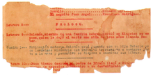 Torn piece of paper with typewritten text in red or black along the lines
