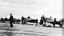 Polish Air Force Academy airfield with four planes and a number of men around them