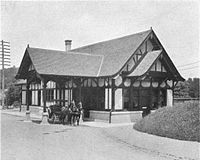 A Tudor Revival train station with a horse and buggy