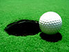 En golfboll på väg ner i ett hål