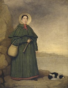 Portrait of a woman in bonnet and long dress holding rock hammer, pointing at fossil next to spaniel dog lying on ground.