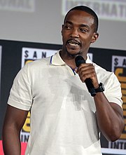 Anthony Mackie on-stage at San Diego Comic-Con holding a microphone