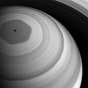 Image en noir et blanc de Saturne vue de haut et montrant un hexagone foncé au pôle nord.